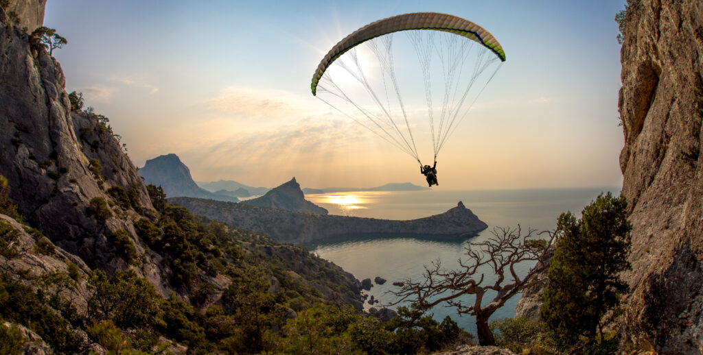 Paraplane between cliffs by the sea